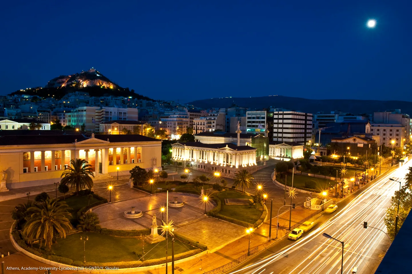 The Academy of Athens lit at night with Lycabettus behind